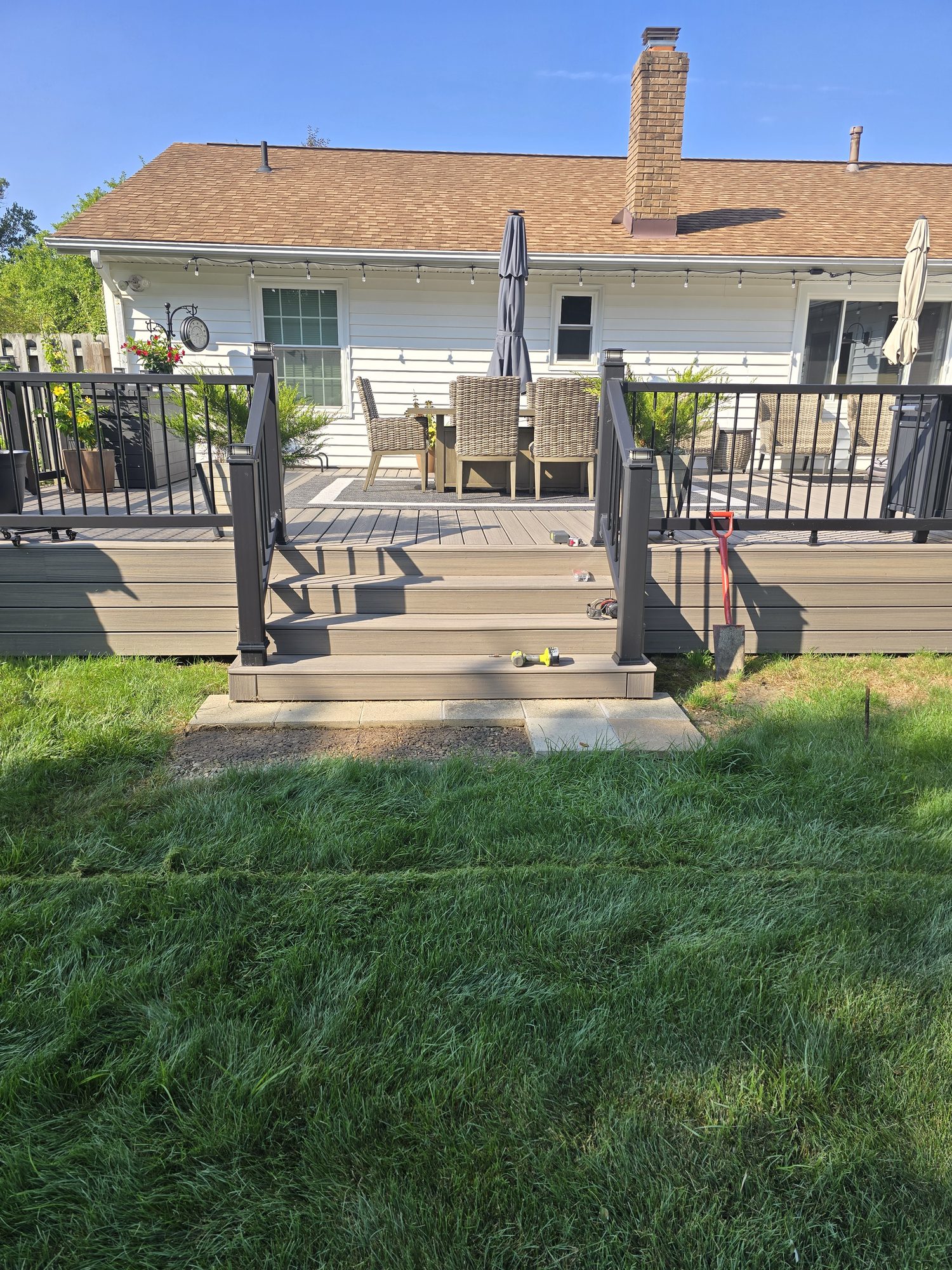 Composite deck stairs and landing with freshly laid sod in the backyard